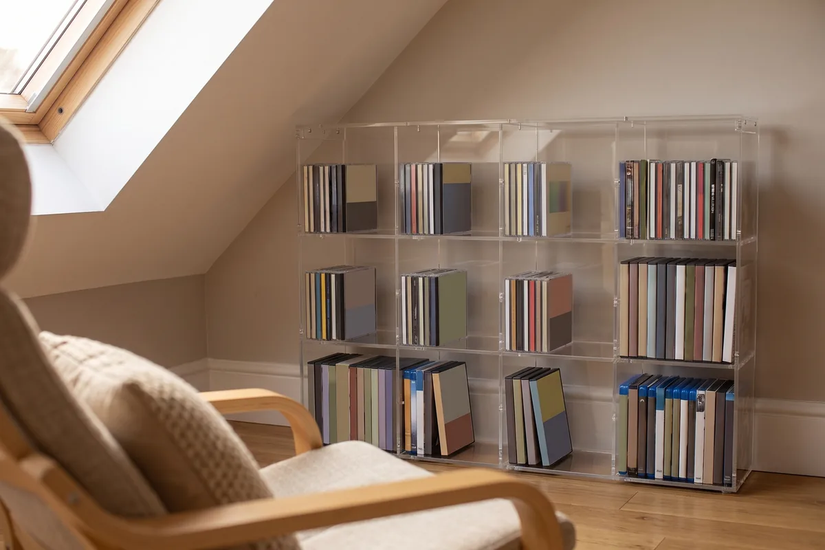 Made-to-measure acrylic media rack in a recess under a sloping ceiling