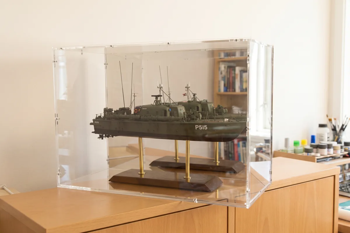 Radio-controlled ship model under a removable acrylic display case without a base
