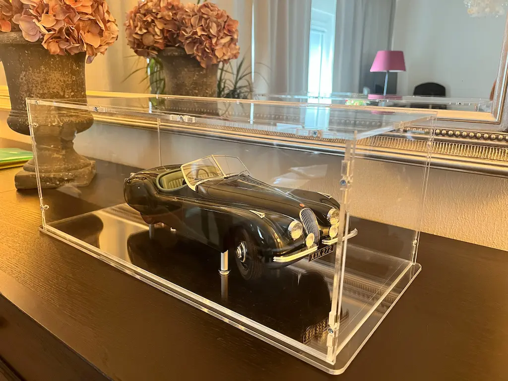 Sora made-to-measure display case over a black Jaguar roadster model car, presented on a dark base plate with a reflection